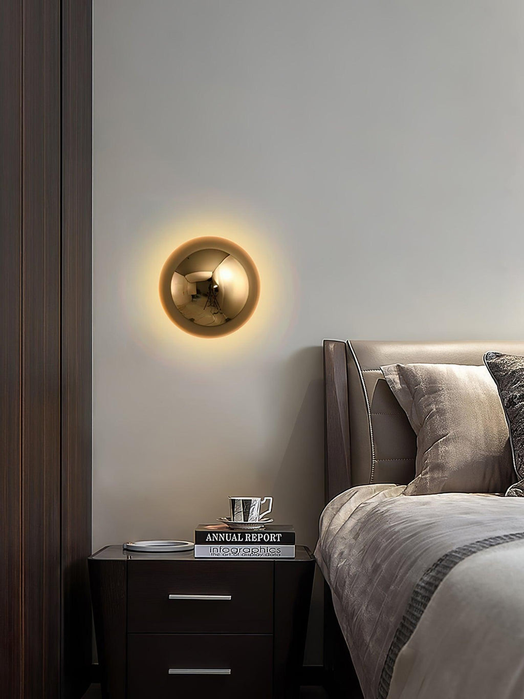 Polished sphere wall sconce glowing beside seating