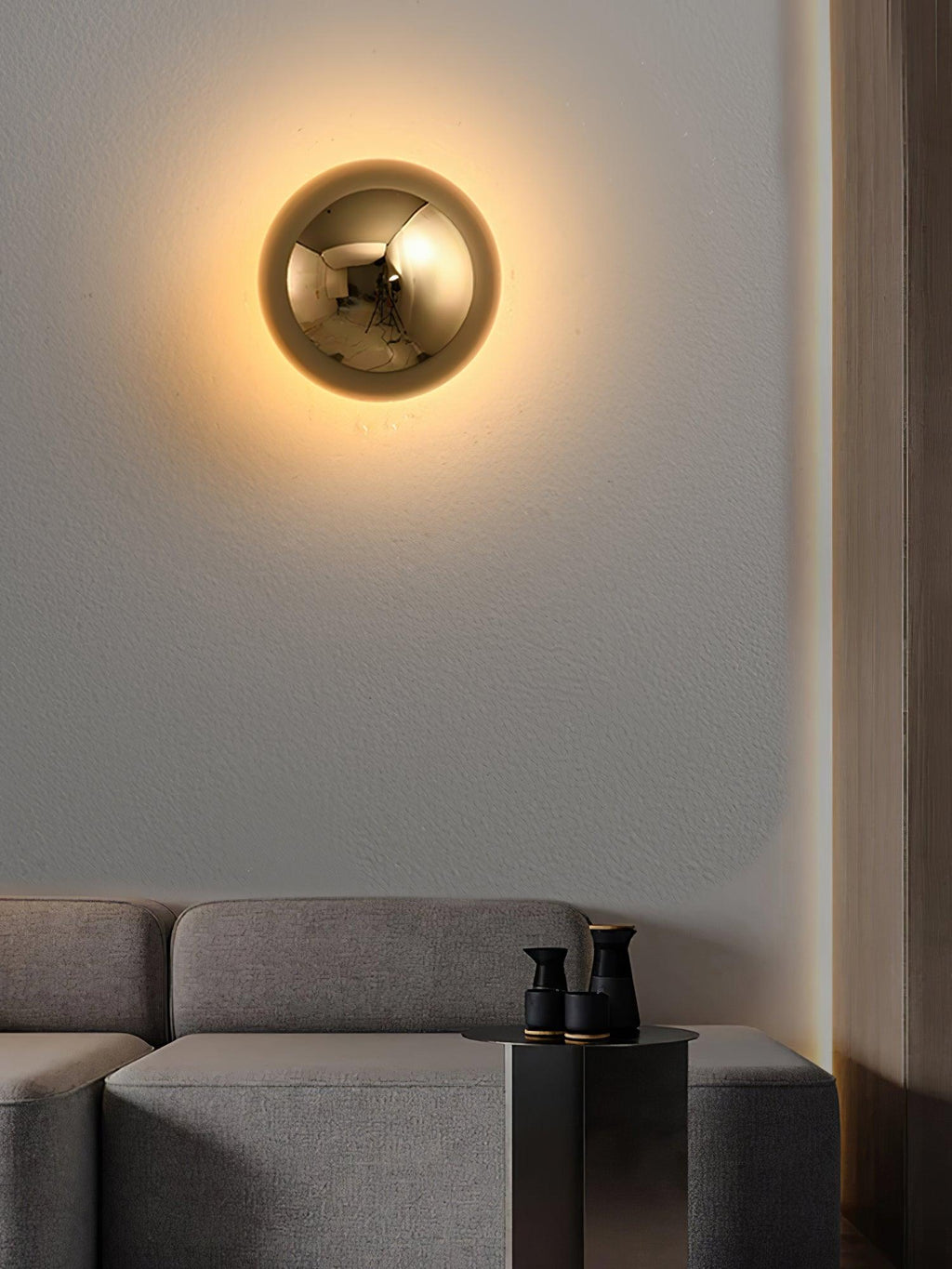 Polished sphere wall sconce mounted in a modern room
