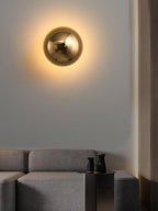 Polished sphere wall sconce mounted in a modern room
