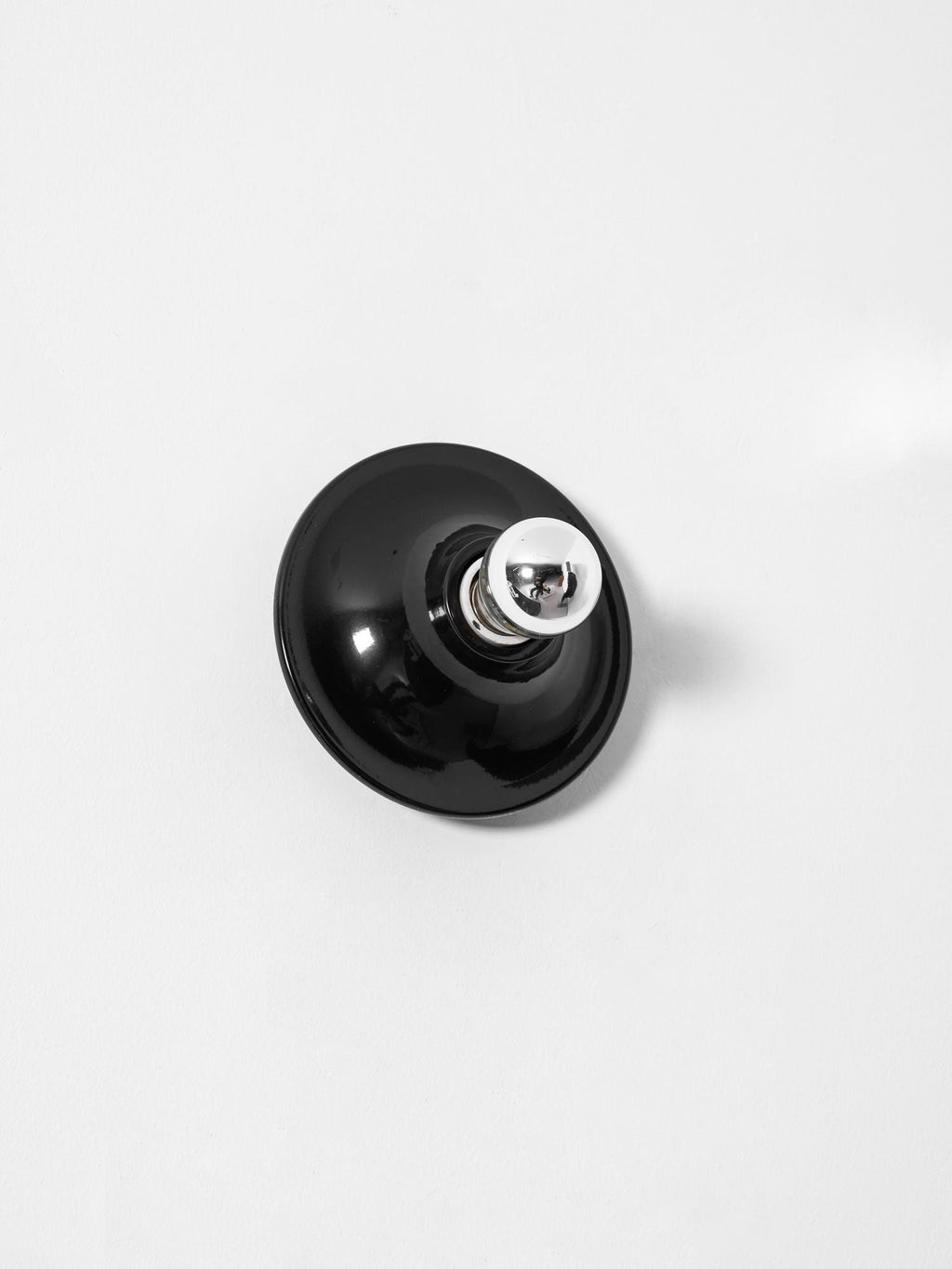 Eclipta wall sconce mounted above a seating area