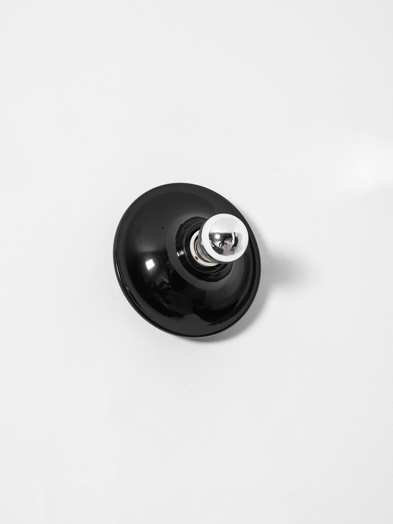 Eclipta wall sconce mounted above a seating area