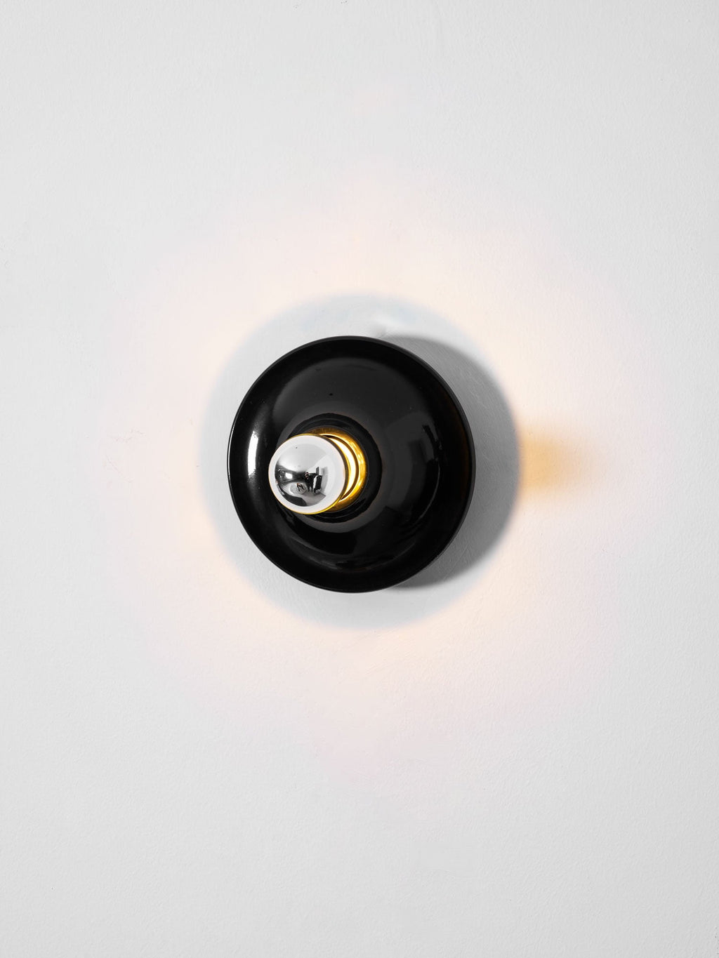 Eclipta wall sconce with its curved base seen in detail