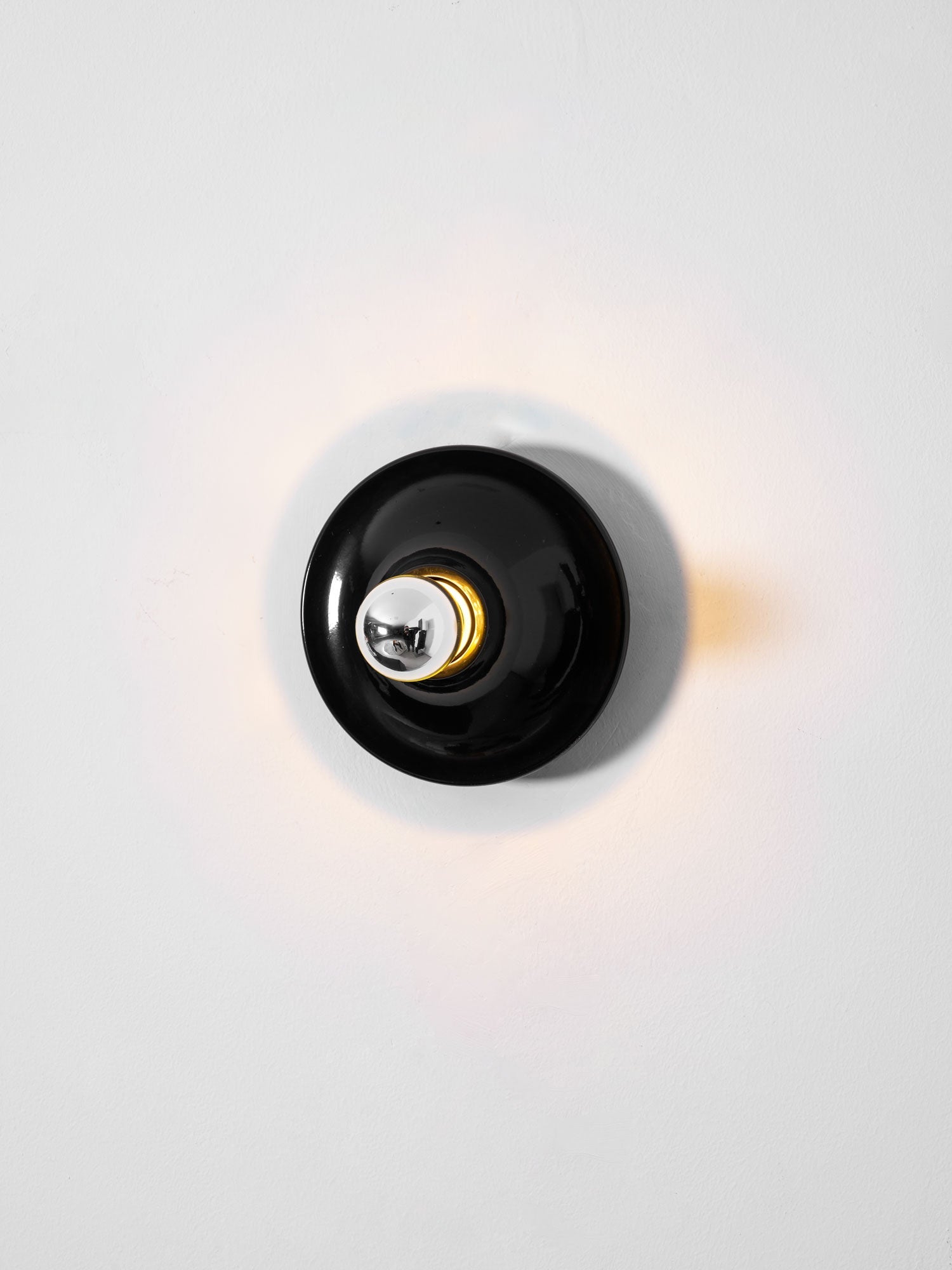 Eclipta wall sconce with its curved base seen in detail