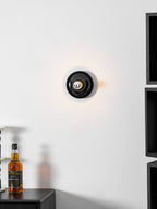 Eclipta wall sconce in a white finish on a textured wall