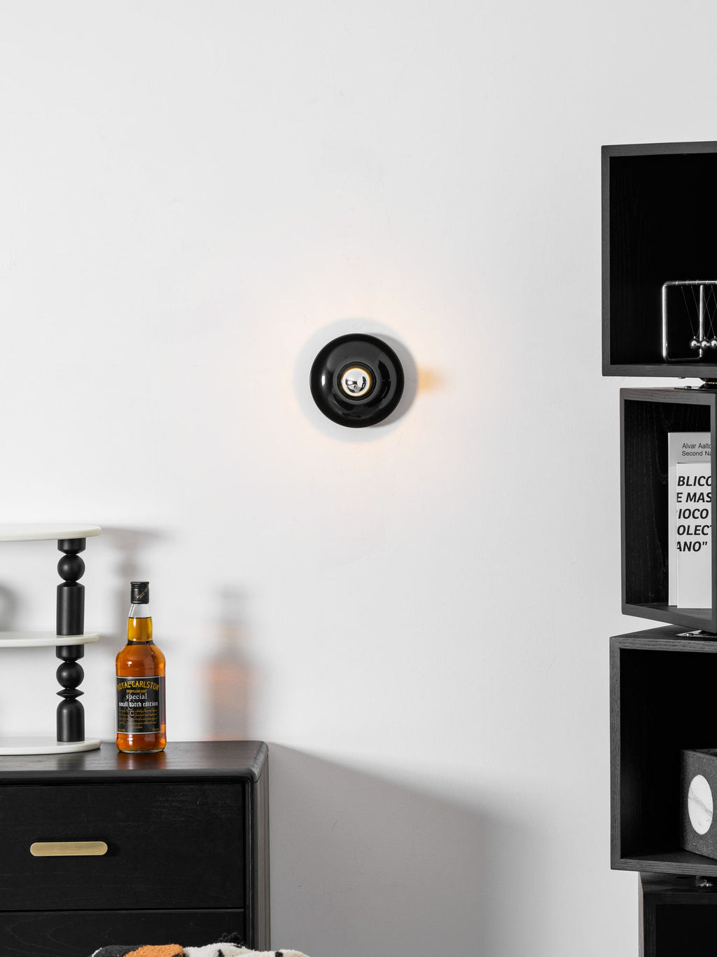 Eclipta wall sconce casting a soft halo in a dim room