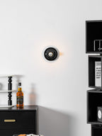 Eclipta wall sconce casting a soft halo in a dim room