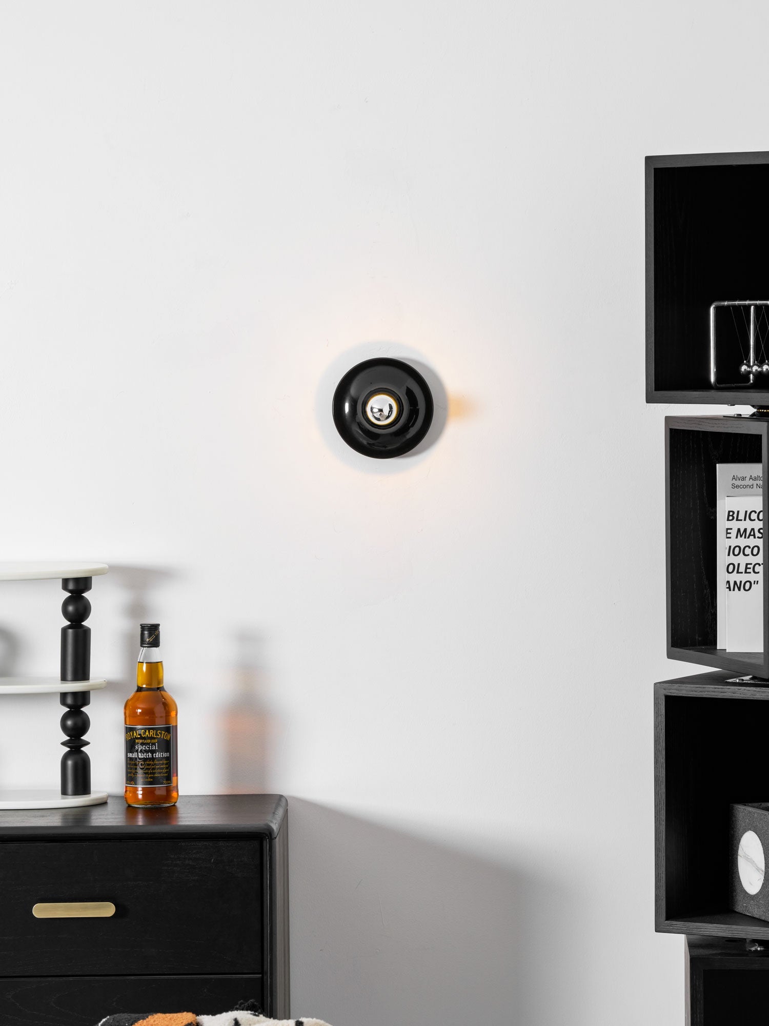 Eclipta wall sconce casting a soft halo in a dim room