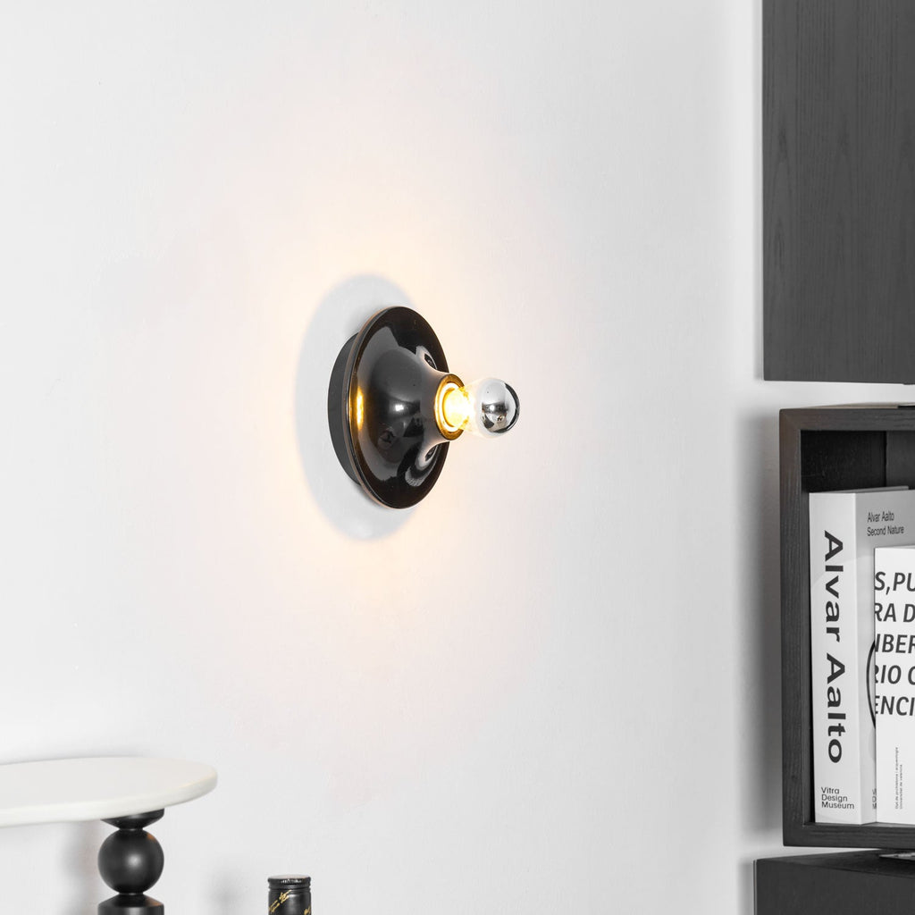 Eclipta wall sconce with electroplated glass bulb reflecting light