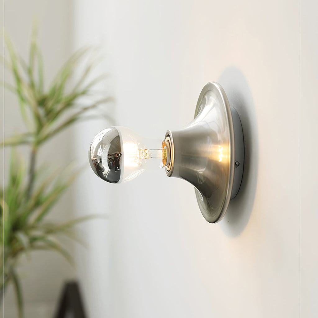 Eclipta wall sconce in a gold finish against a neutral wall