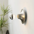 Eclipta wall sconce in a gold finish against a neutral wall