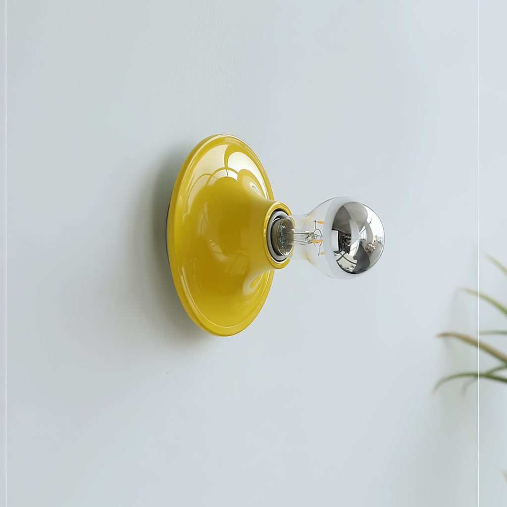 Eclipta wall sconce mounted above a console in a styled space