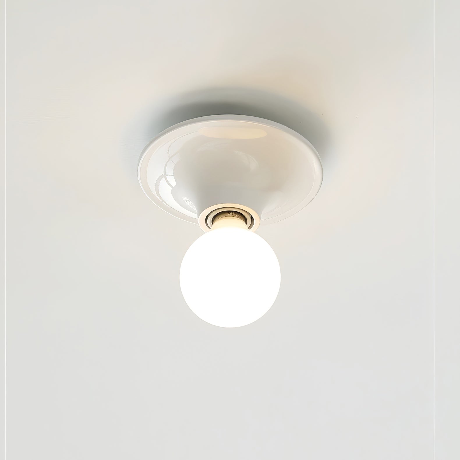 Eclipta wall sconce with mirrored bulb reflecting the room