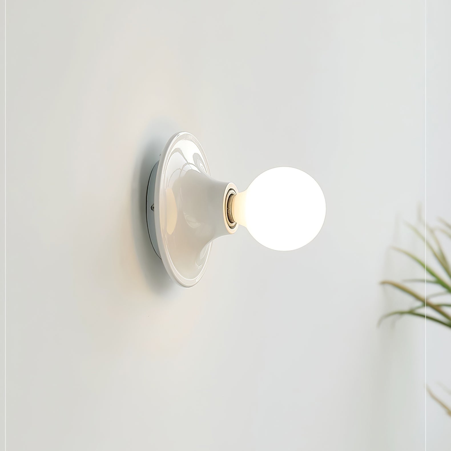Eclipta wall sconce shown in profile against a plain wall