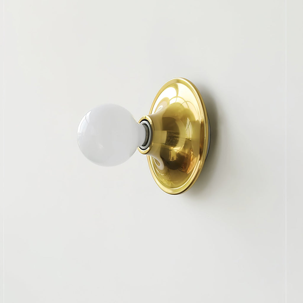 Eclipta wall sconce glowing warmly in a minimalist hallway