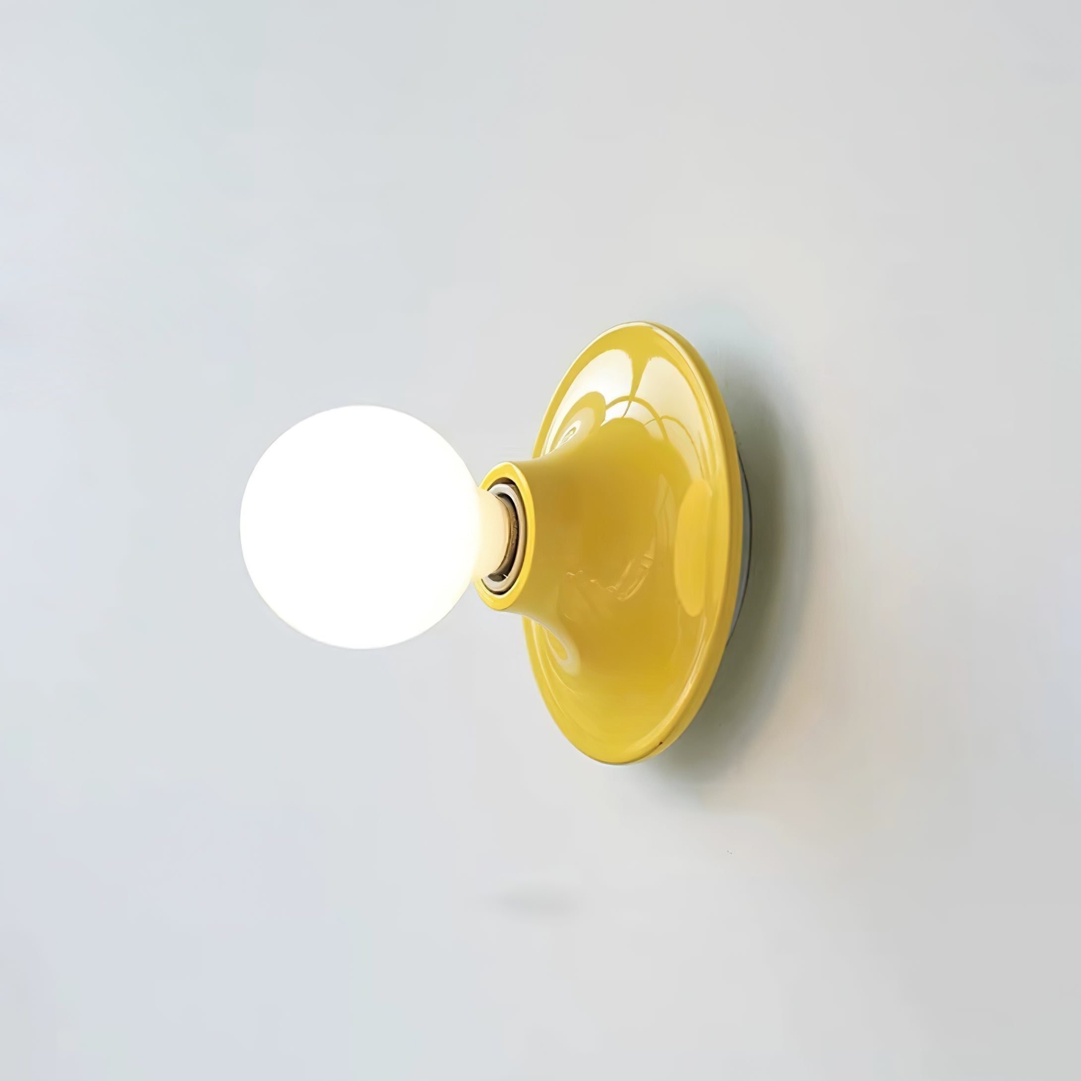 Eclipta wall sconce mounted beside a doorway in a modern room