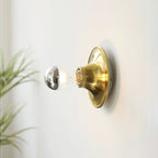 Eclipta wall sconce shown close up with its trumpet-shaped base