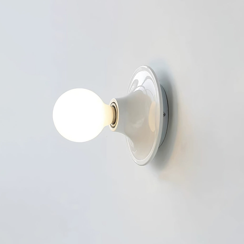 Eclipta wall sconce glowing softly in a minimalist interior