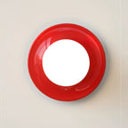 Eclipta wall sconce in a red finish against a pale wall