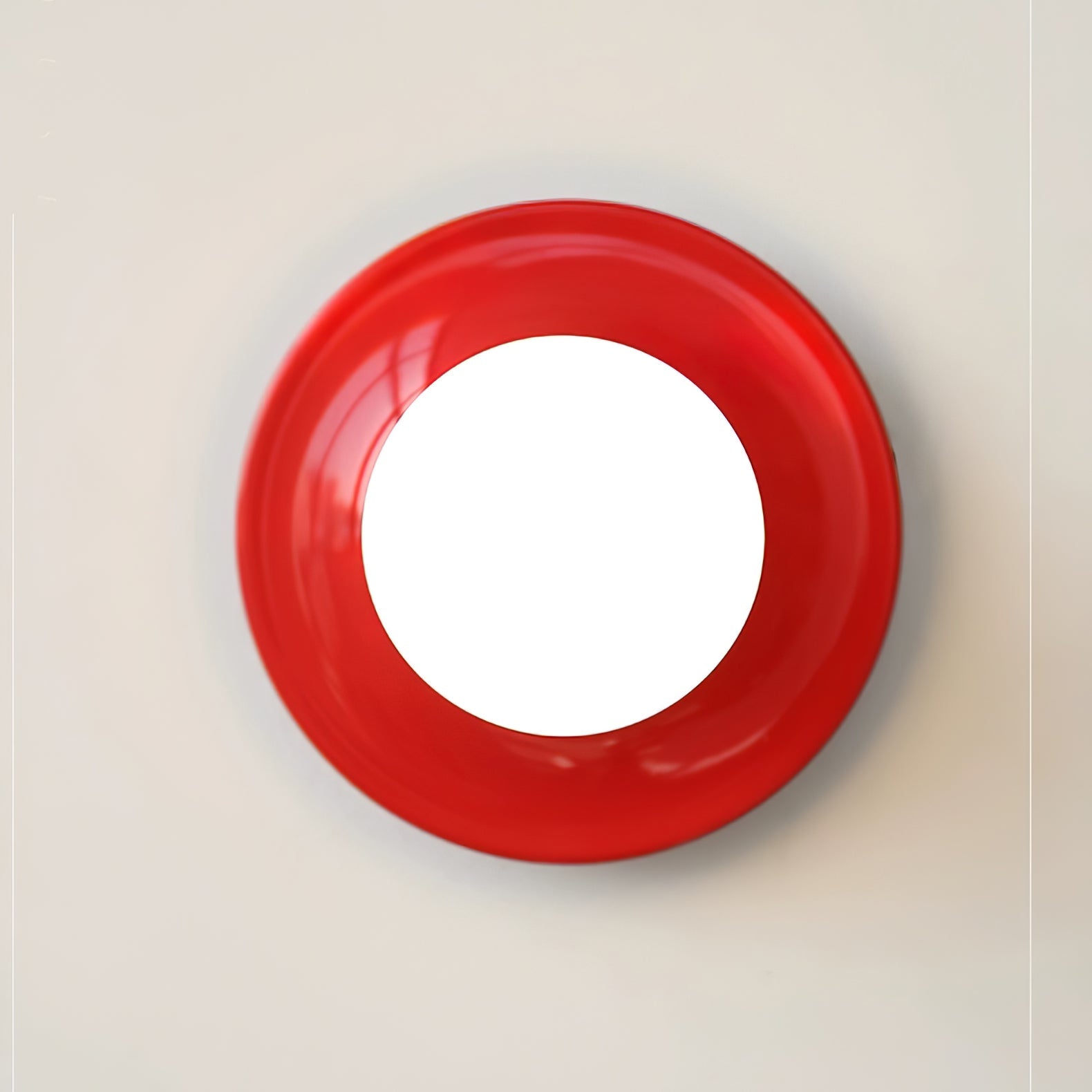 Eclipta wall sconce in a red finish against a pale wall