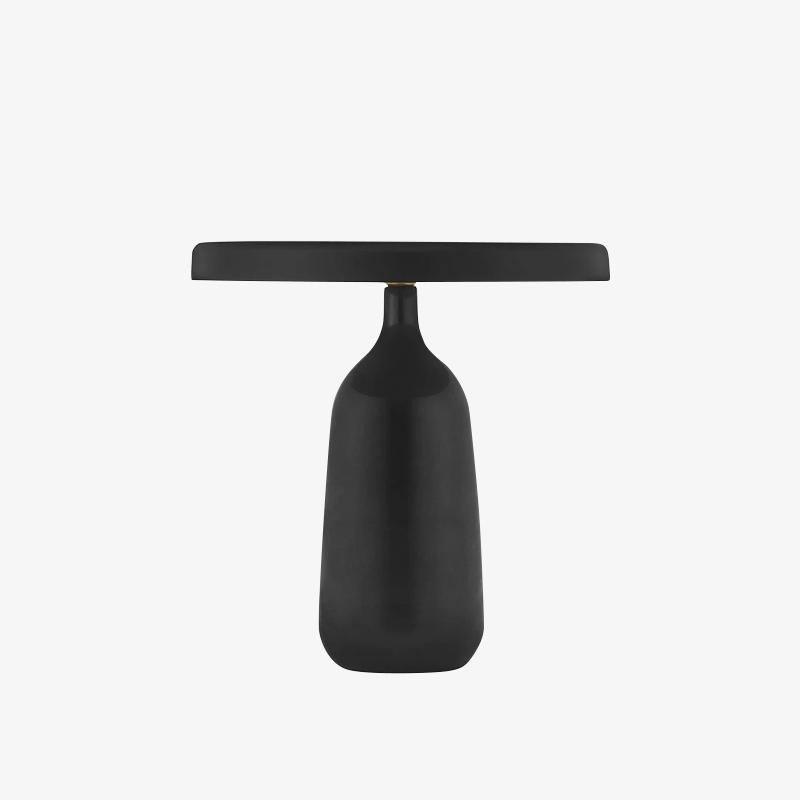 Close silhouette of the black Clérachic table lamp against a plain white background, showing the bottle-shaped base and shade.