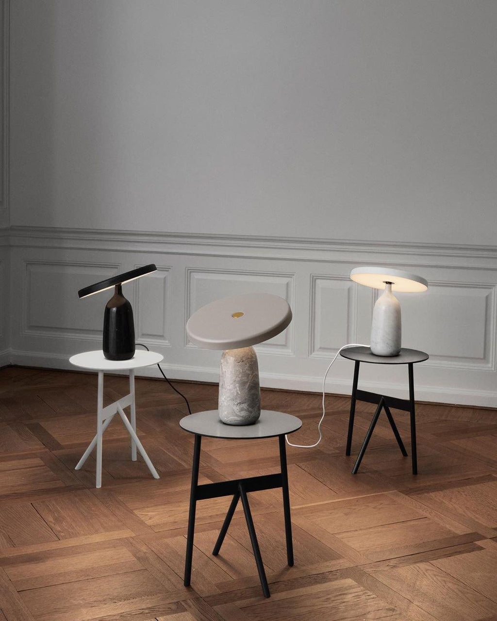 The same three Clérachic table lamps from further back, showing the full herringbone parquet floor beneath them.