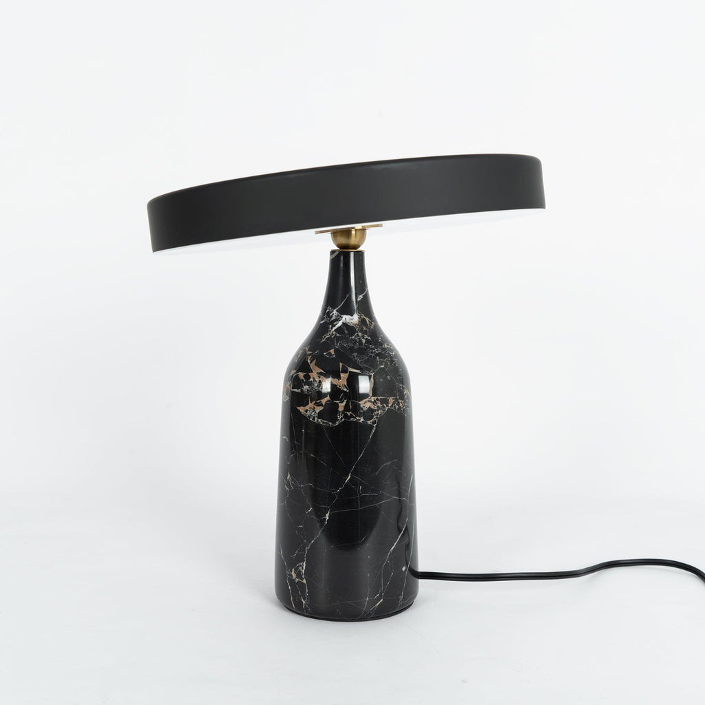 Black marble Clérachic table lamp with visible gold veining, disc shade held level, shown on a plain white background.