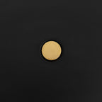 Macro close-up of the brass pivot knob at the centre of the Clérachic table lamp's black disc shade.