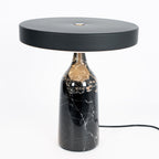 Black marble Clérachic table lamp, disc shade held level, medium studio crop with its cord visible on white.