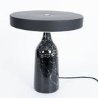 Black marble Clérachic table lamp, disc shade held level, a slightly wider studio crop with its cord visible.