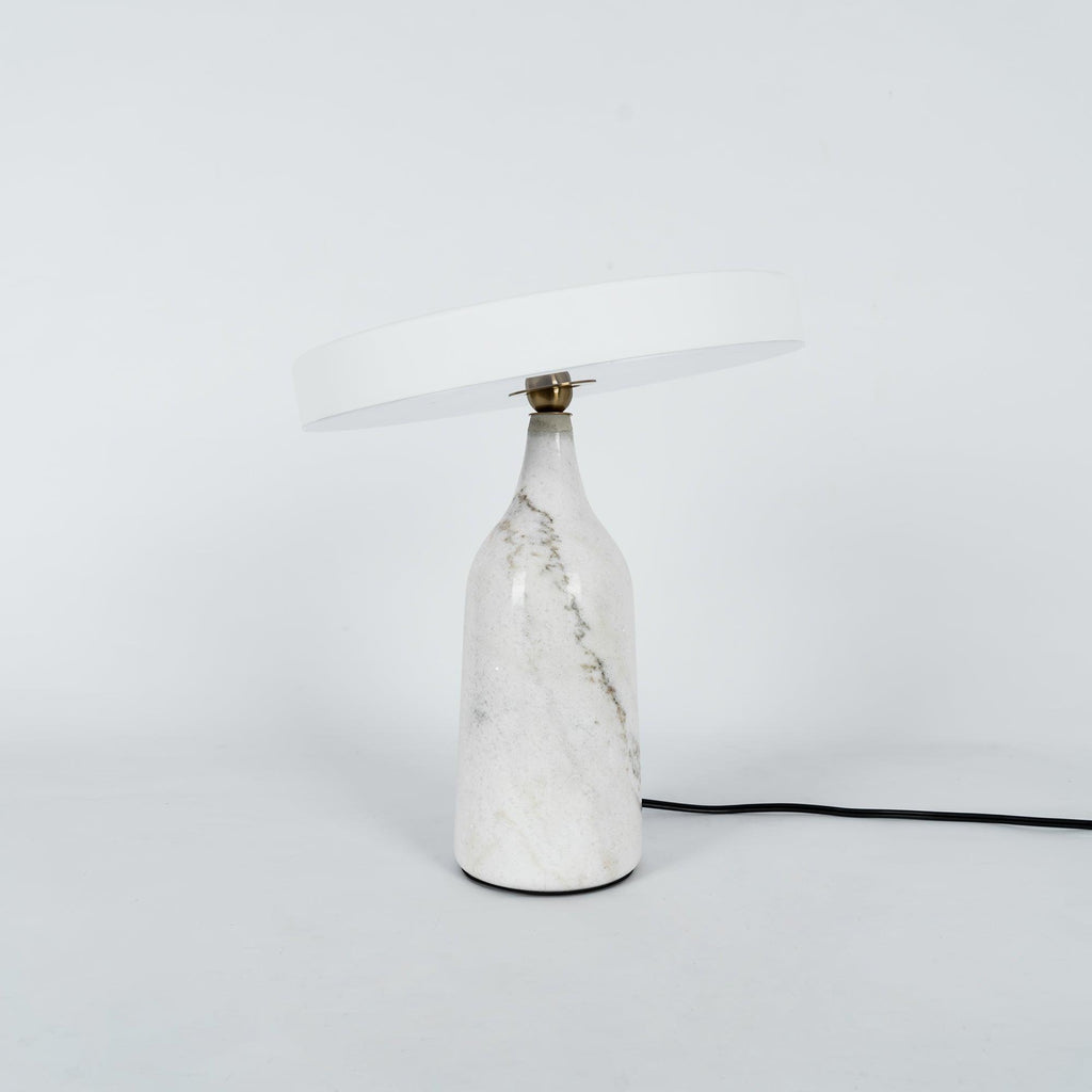 White marble Clérachic table lamp with its disc shade held level, shown with its cord on a plain background.