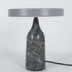 Grey marble Clérachic table lamp with a matching grey disc shade held level, shown with its cord on white.