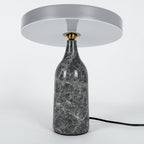 Grey marble Clérachic table lamp with its disc shade angled nearly edge-on, shown on a plain white background.