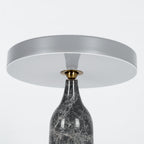 Close crop of the grey marble Clérachic table lamp's shade and neck, disc held level on a white background.