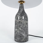 Close-up of the grey marble base on the Clérachic table lamp, showing its pale veined stone texture.
