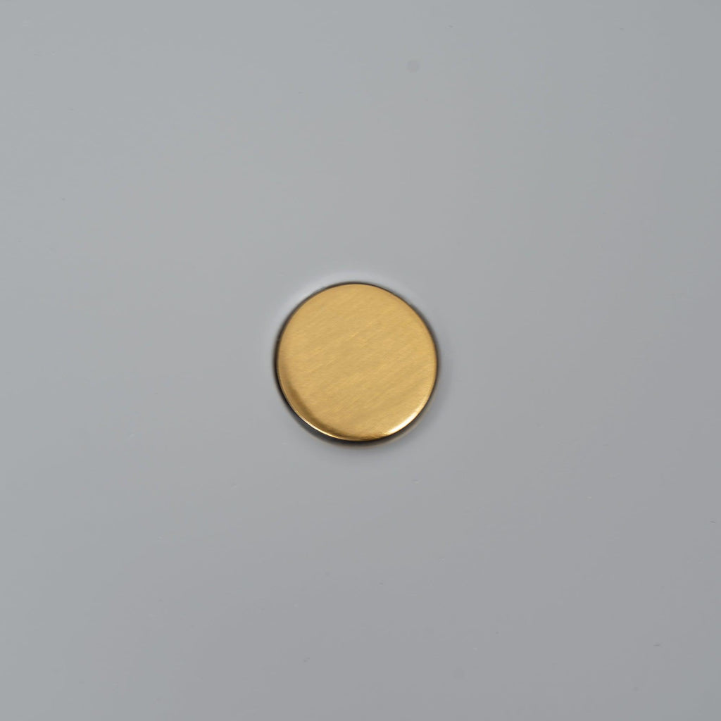 Macro close-up of the brass pivot knob at the centre of the Clérachic table lamp's grey disc shade.