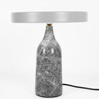 Grey marble Clérachic table lamp with its disc shade held level, shown with its cord on a plain white background.