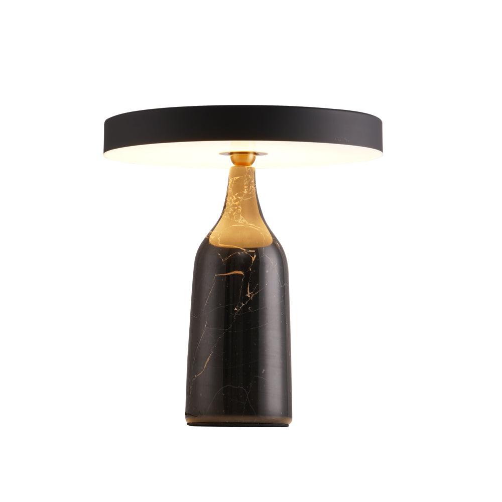 On a grey marble base, the disc shade of this Clérachic lamp sits level and glows in a warm ring, cut out on plain white.