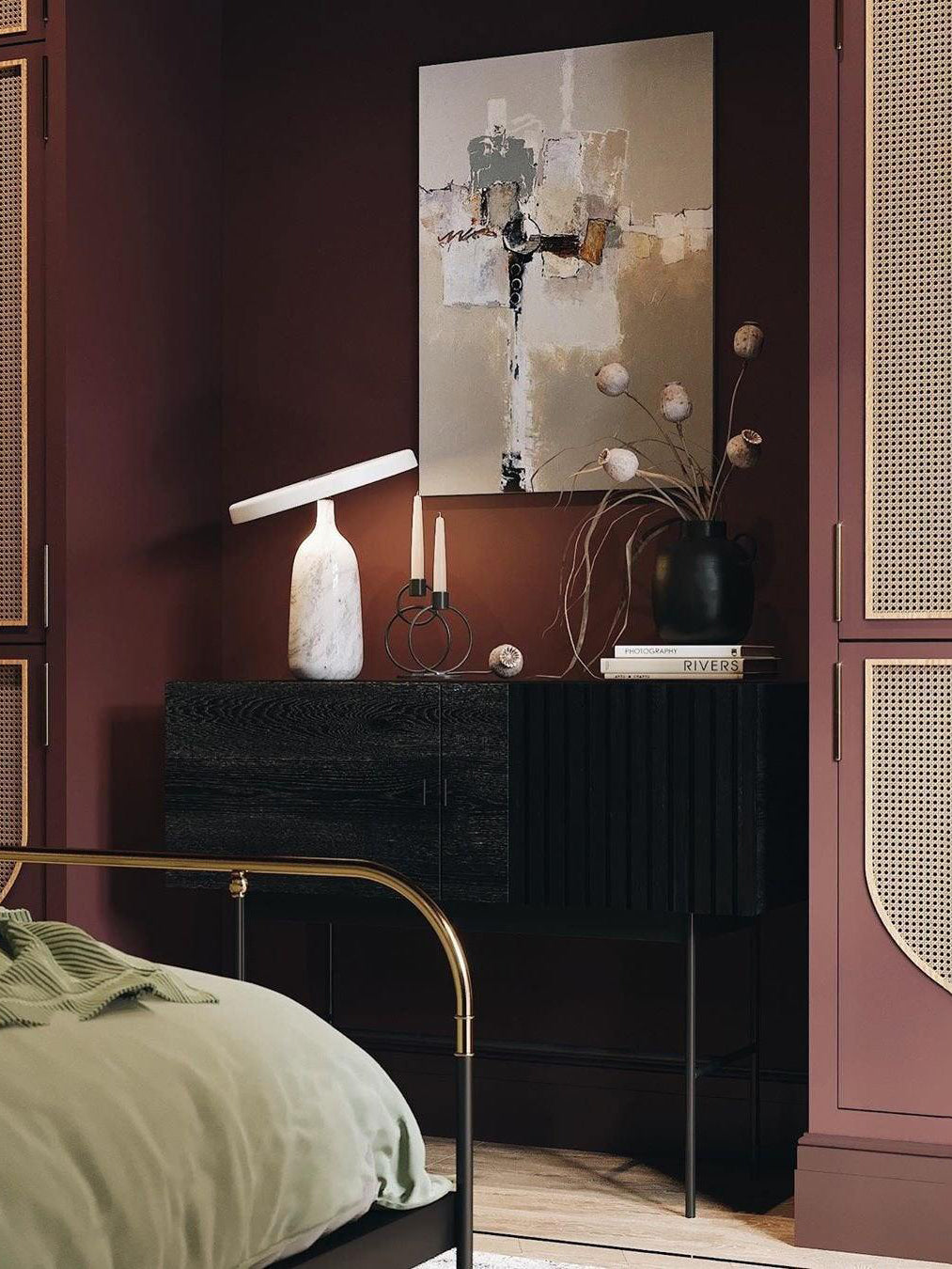 Grey marble Clérachic table lamp with its disc shade tilted steeply, beside pink roses and a dark blue sofa.