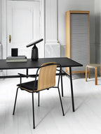 Black Clérachic table lamp on the black desk, a wider view of the white study with the wood-slat room divider.