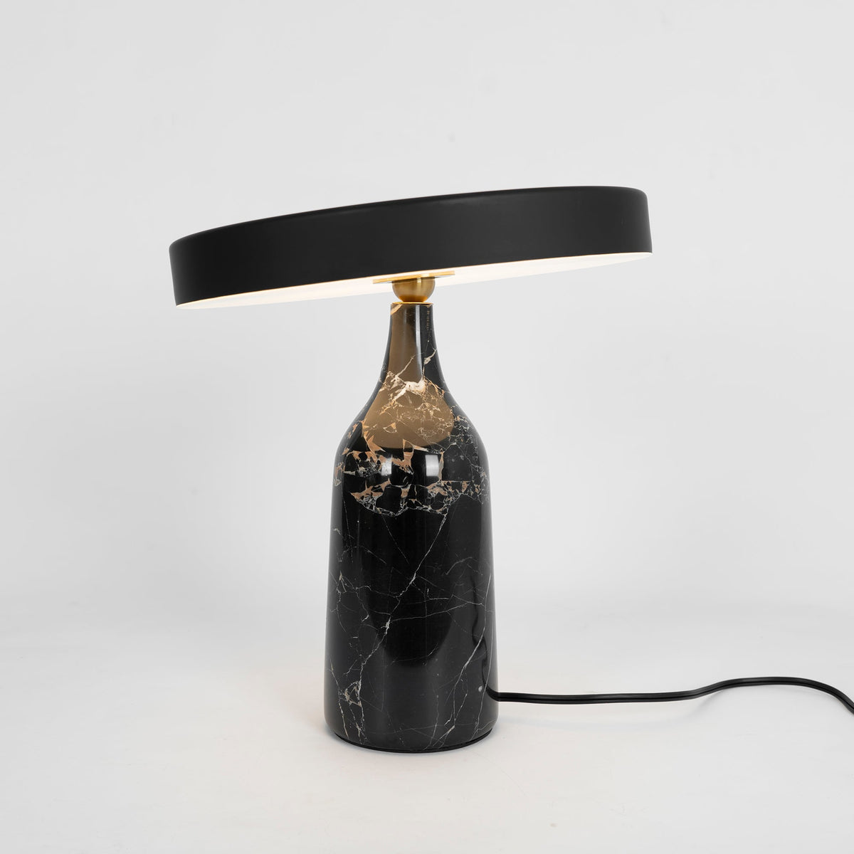 Black marble Clérachic table lamp with its disc shade tilted, tall studio crop on a plain white background.