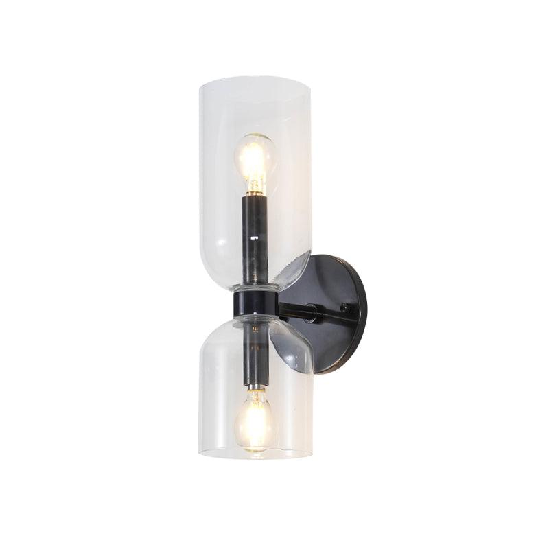On a plain white background, this matt black Clérachic wall light's clear shades glow faintly.