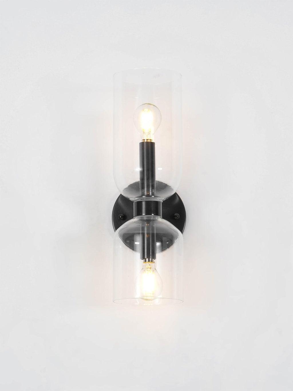 A close crop shows the lit bulb inside this matt black Clérachic wall light's smoke grey shade.