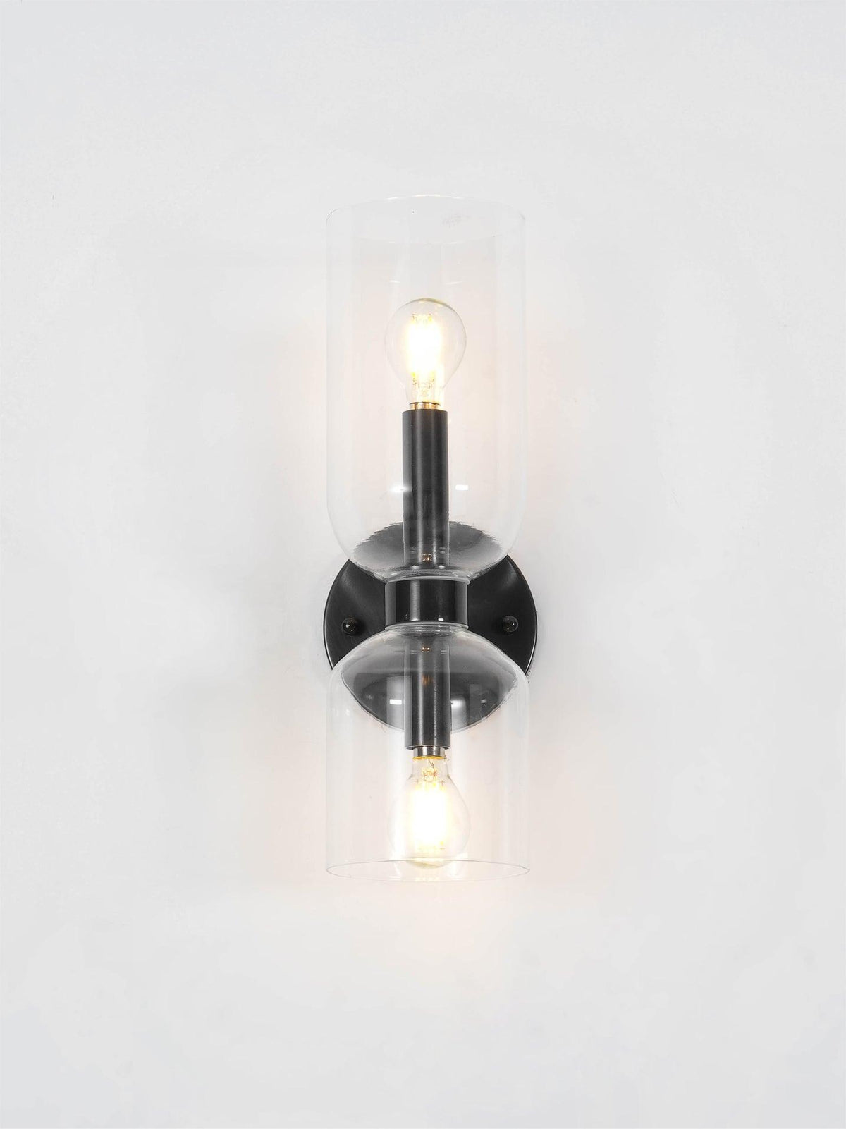 A close crop shows the lit bulb inside this matt black Clérachic wall light's smoke grey shade.