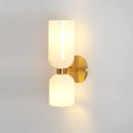 Both opal shades on this gold Clérachic wall light glow brightly against a plain white wall.