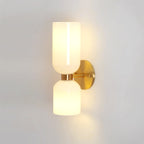 Both opal shades on this gold Clérachic wall light glow brightly against a plain white wall.