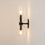 Seen from the side, this matt black Clérachic wall light's clear glass shades glow gently.