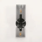 Smoke grey glass shades glow around the bulbs of this matt black Clérachic wall light on white.
