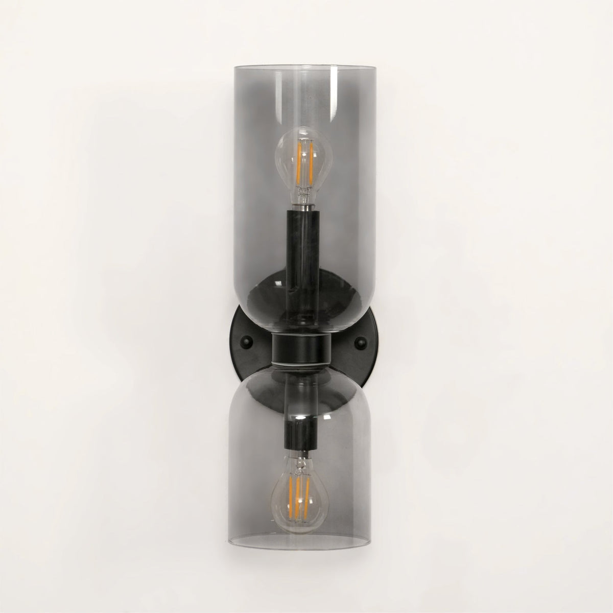 Smoke grey glass shades glow around the bulbs of this matt black Clérachic wall light on white.