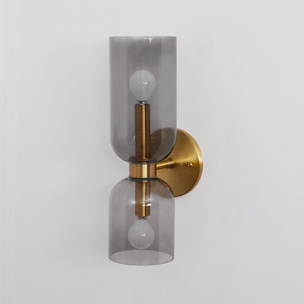 Angled against white, this gold Clérachic wall light's smoke grey shades glow around the bulbs.
