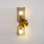 A front view of this gold Clérachic sconce shows smoke grey glass glowing over both bulbs.